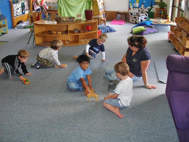 5 children and 1 adult sitting on the floor