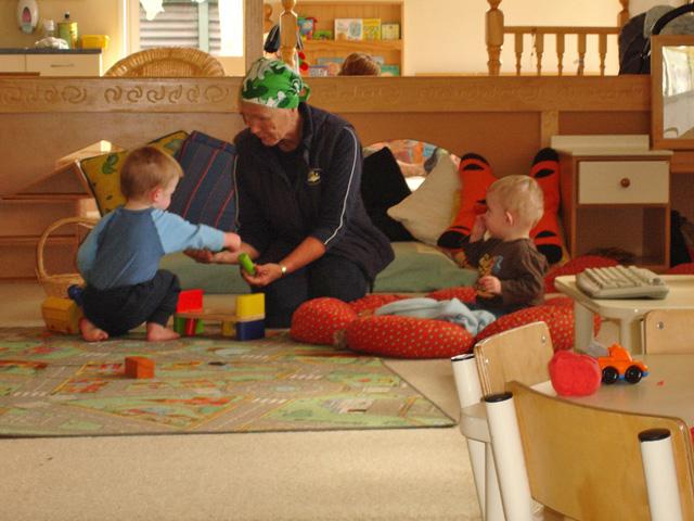 2 toddlers and an adult sitting on the floor