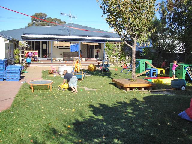 A child playing with a toy truck in the outdoor activity space