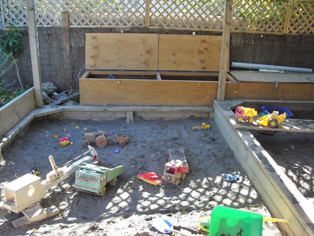 Sandbox with toy trucks