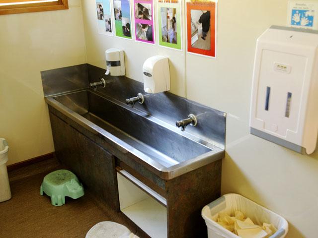 Trough style sink with soap dispensers and hand towels